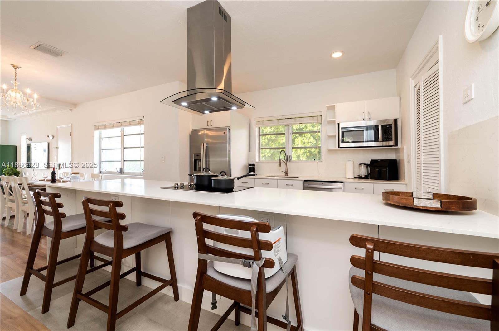 501 Southwest 24th Road, Unit 501 Miami, FL 33129 - Photo 4 of 29 a kitchen with a dining table chairs and white cabinets