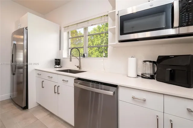 a kitchen with stainless steel appliances granite countertop a sink stove and microwave