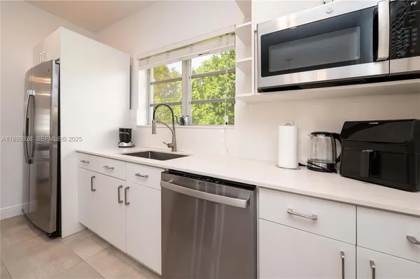 a kitchen with stainless steel appliances granite countertop a sink stove and microwave