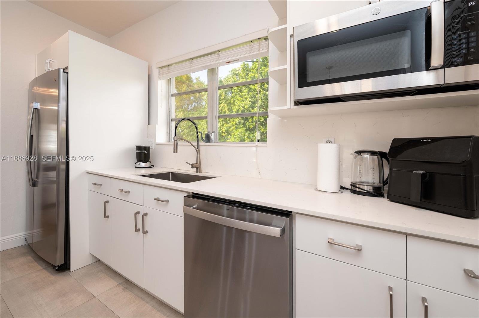 501 Southwest 24th Road, Unit 501 Miami, FL 33129 - Photo 5 of 29 a kitchen with stainless steel appliances granite countertop a sink stove and microwave
