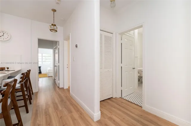 a view of a hallway with wooden floor and dining room