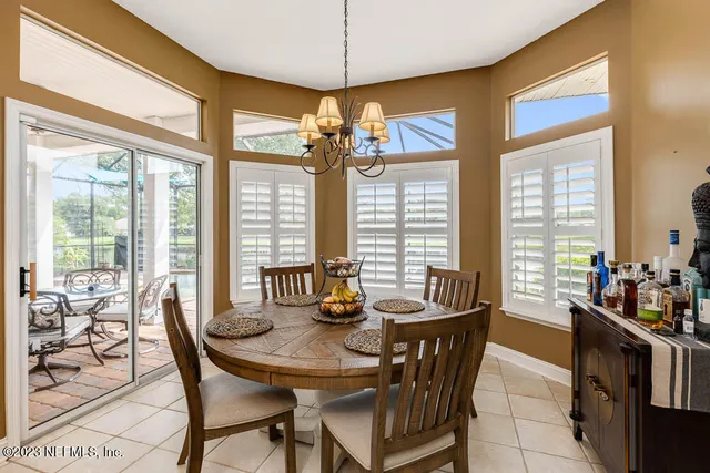 a dining room with furniture a chandelier and wooden floor