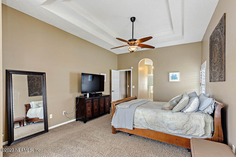 332 Maplewood Drive St. Johns, FL 32259 - Photo 17 of 35 a bedroom with a bed and a chandelier