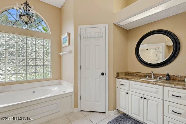 a bathroom with a tub sink and mirror
