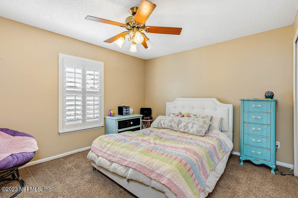 332 Maplewood Drive St. Johns, FL 32259 - Photo 22 of 35 a bedroom with a bed a dresser and a window