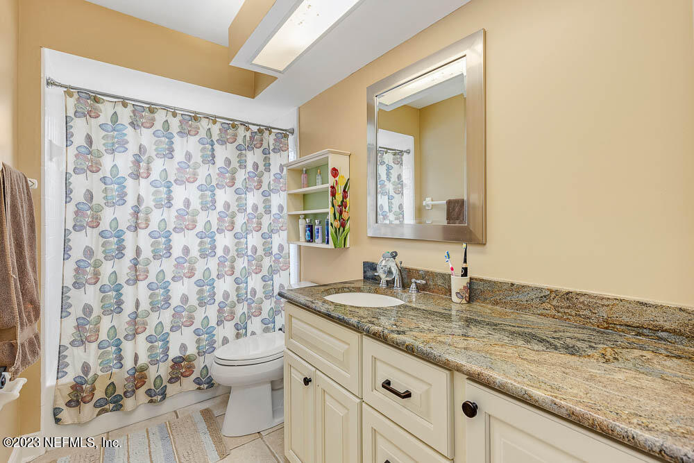 332 Maplewood Drive St. Johns, FL 32259 - Photo 24 of 35 a bathroom with a granite countertop sink a toilet and a mirror