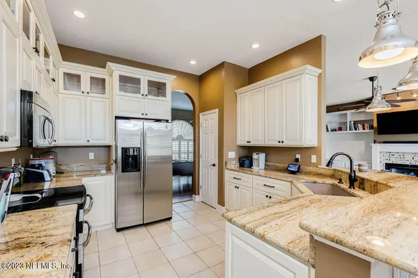 a kitchen with granite countertop a sink a counter top space appliances and cabinets