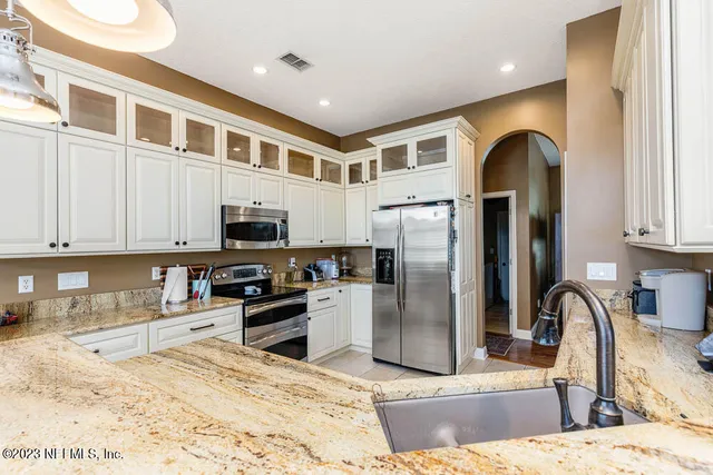 a kitchen with stainless steel appliances granite countertop a refrigerator and a sink