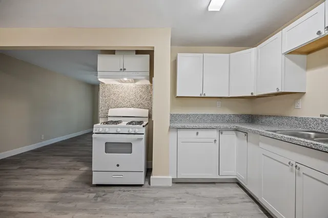 a kitchen with white cabinets and white appliances