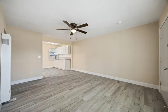 a view of a big room with wooden floor and windows