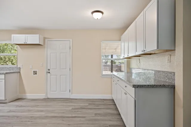 a kitchen with granite countertop white cabinets and a sink