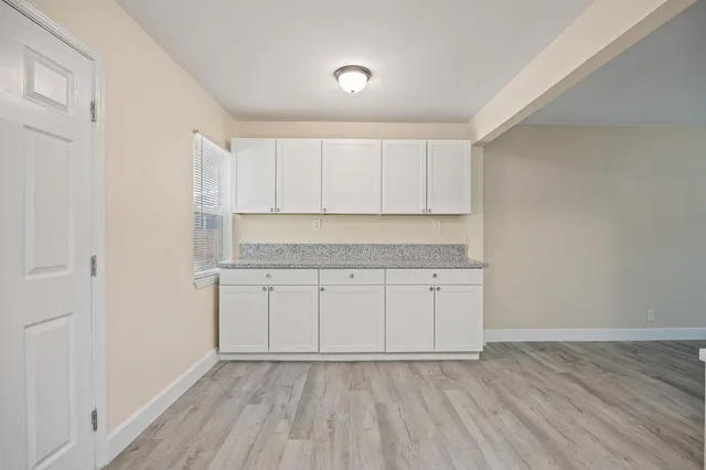 a room view with wooden floor and cabinets