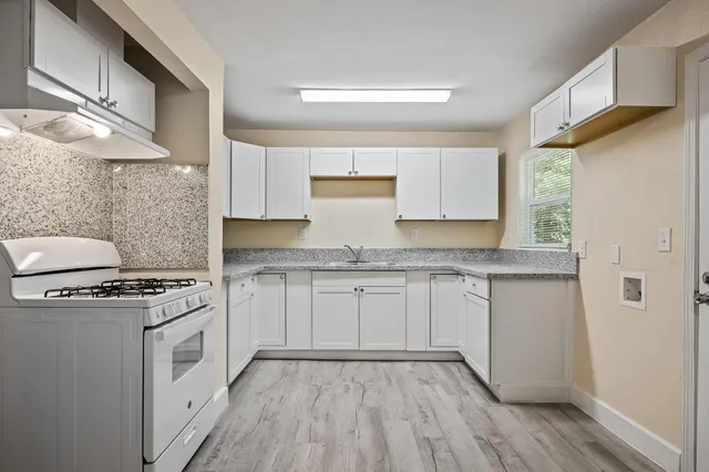 a kitchen with granite countertop white cabinets and white appliances