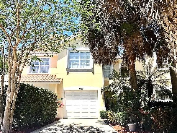 a front view of a house with a tree