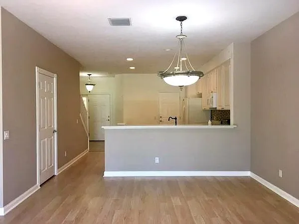 a view of a room with wooden floor and large windows