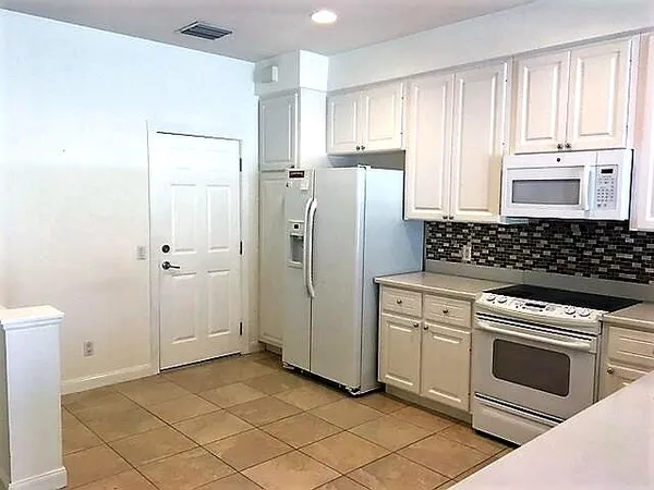 a kitchen with a stove refrigerator and cabinets