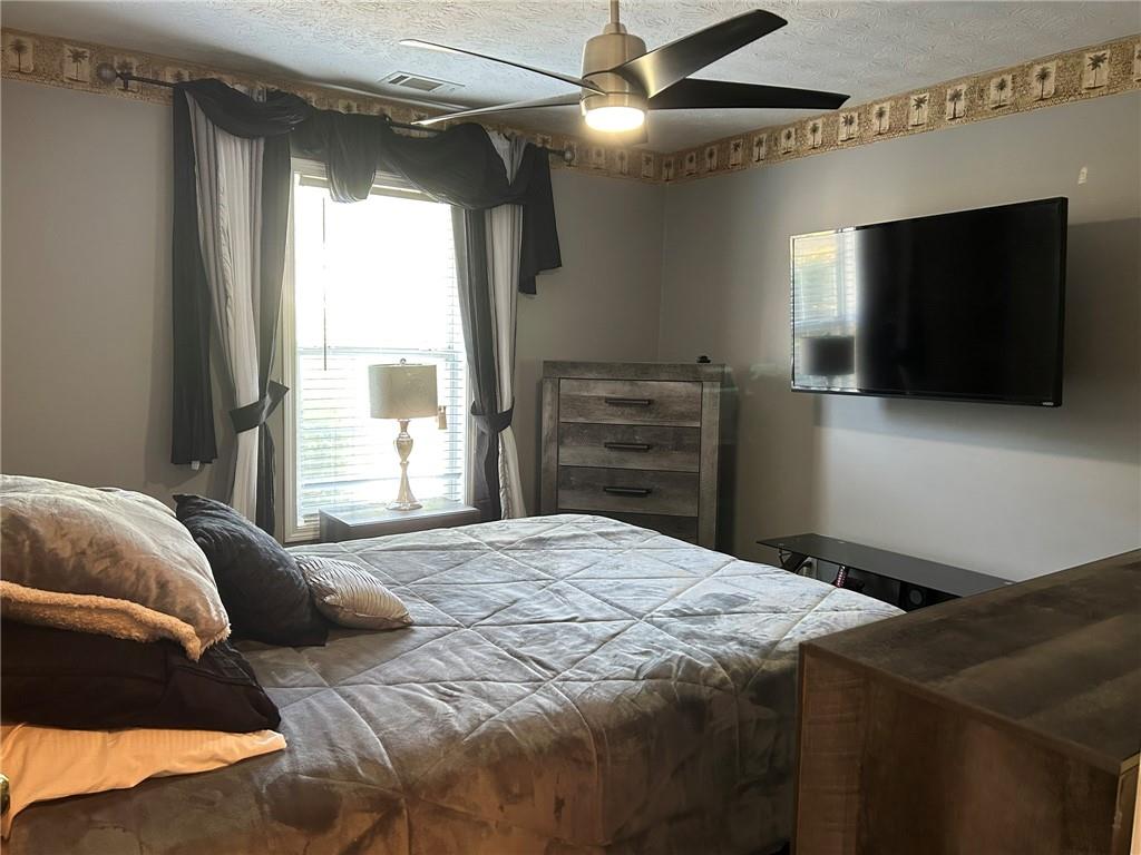 4197 Wyndham Ridge Court Northeast Buford, GA 30519 - Photo 22 of 49 a bedroom with a bed and a flat screen tv