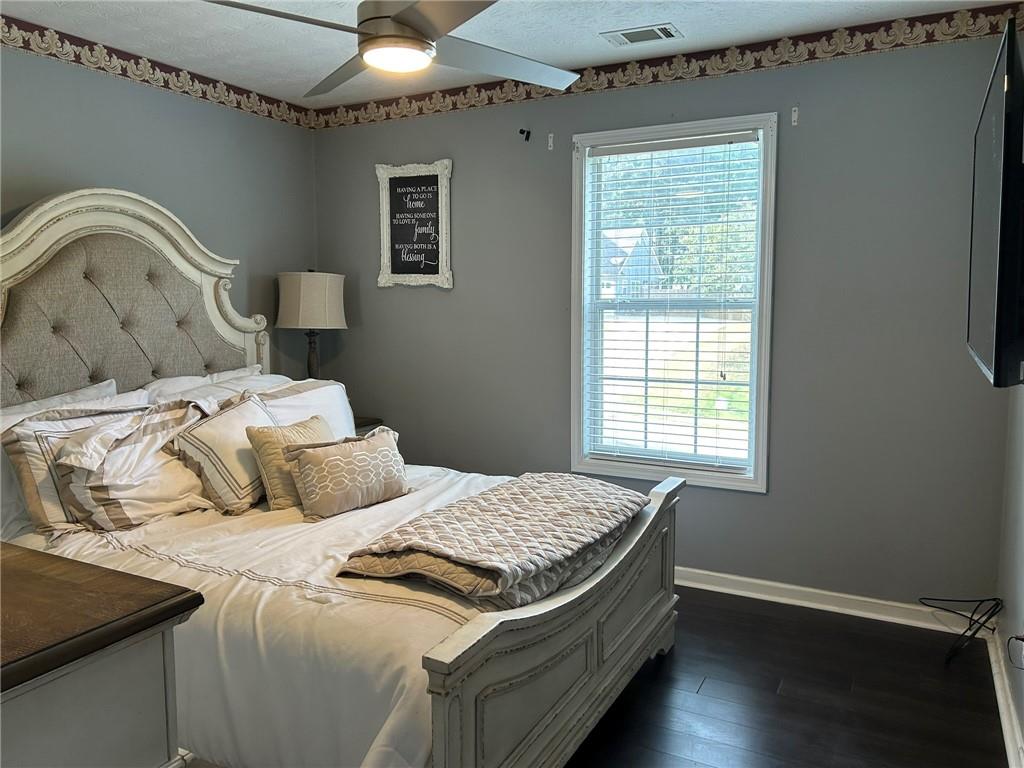 4197 Wyndham Ridge Court Northeast Buford, GA 30519 - Photo 25 of 49 a bedroom with a bed and wooden floor