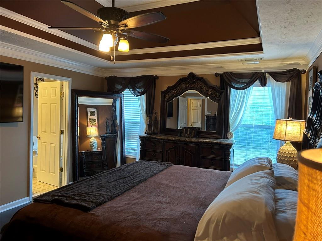 4197 Wyndham Ridge Court Northeast Buford, GA 30519 - Photo 29 of 49 a bedroom with a bed a dresser and potted plants