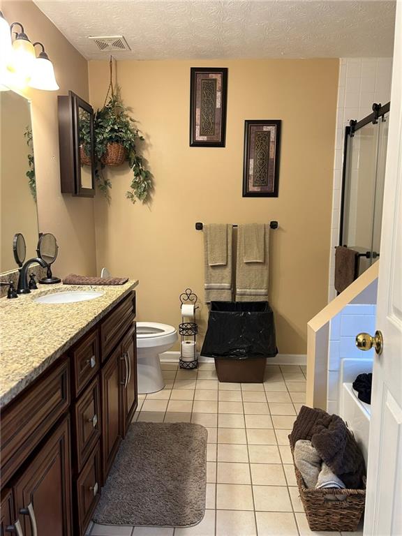 4197 Wyndham Ridge Court Northeast Buford, GA 30519 - Photo 33 of 49 a bathroom with a granite countertop sink a toilet a mirror and vanity