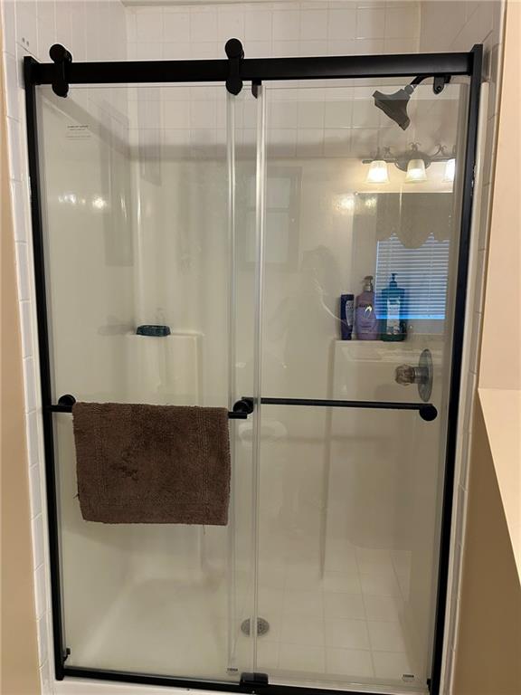 4197 Wyndham Ridge Court Northeast Buford, GA 30519 - Photo 34 of 49 a bathroom with a glass shower door