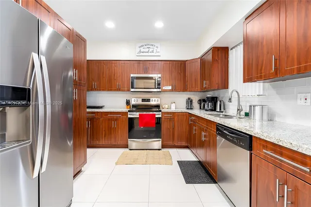 a kitchen with stainless steel appliances granite countertop wooden cabinets a sink and dishwasher