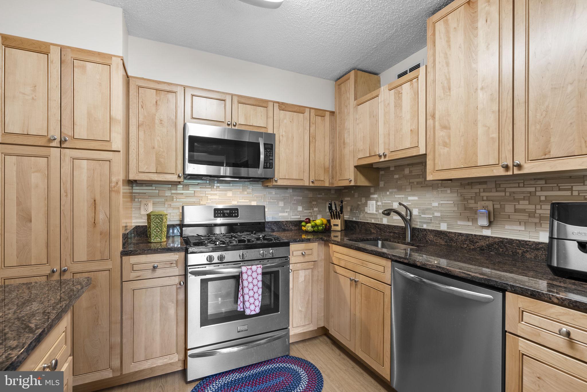 5225 Pooks Hill Road, Unit 804N Bethesda, MD 20814 - Photo 12 of 39 a kitchen with stainless steel appliances granite countertop white cabinets sink and a granite counter top