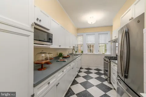 a kitchen with a sink a refrigerator and cabinets