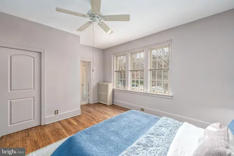 a view of a bedroom with wooden floor and windows