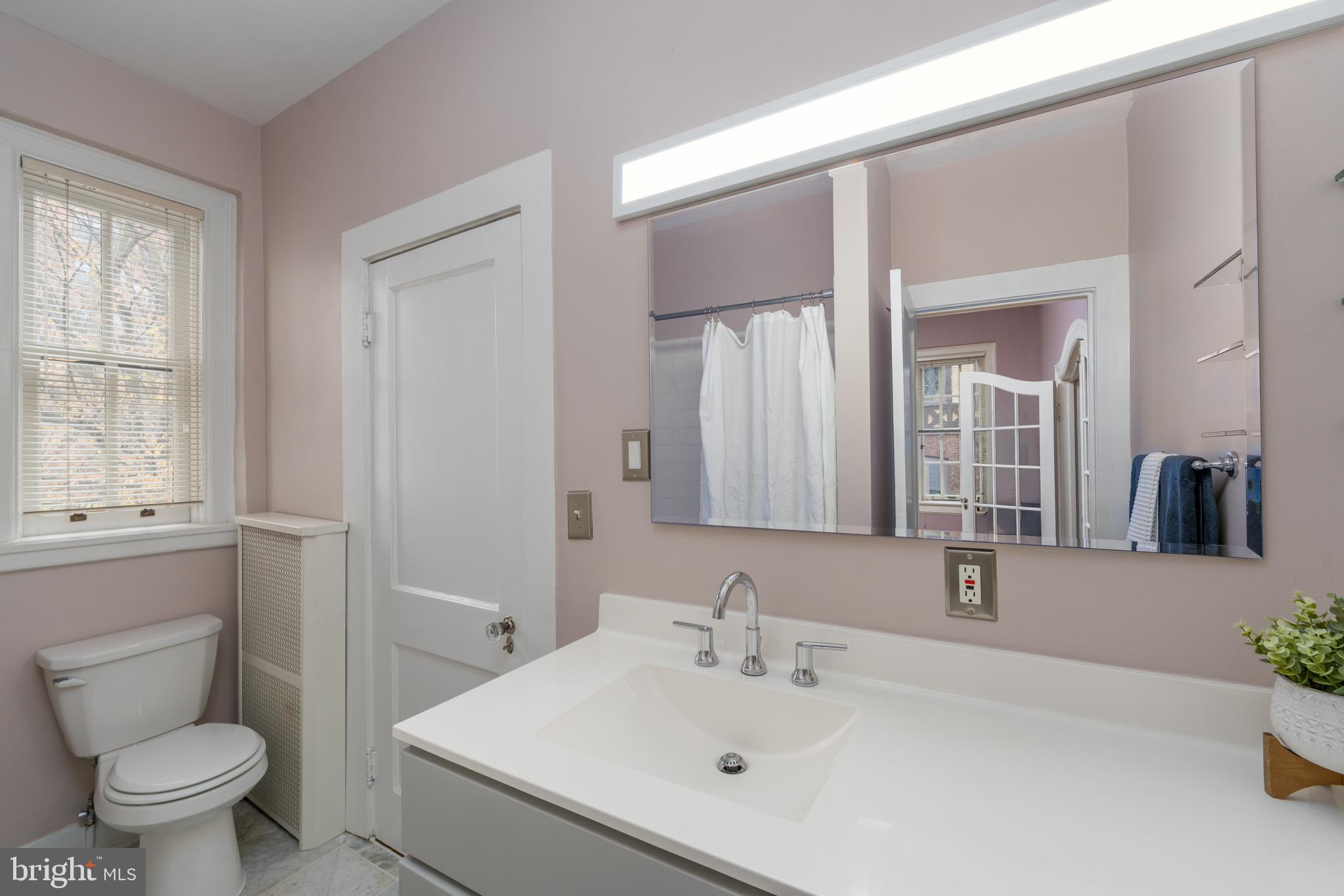 102 West 39th Street, Unit 2B Baltimore, MD 21210 - Photo 27 of 30 a bathroom with a sink toilet and mirror