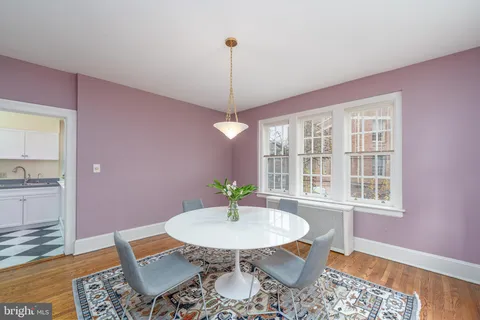 a dining room with furniture a window and wooden floor