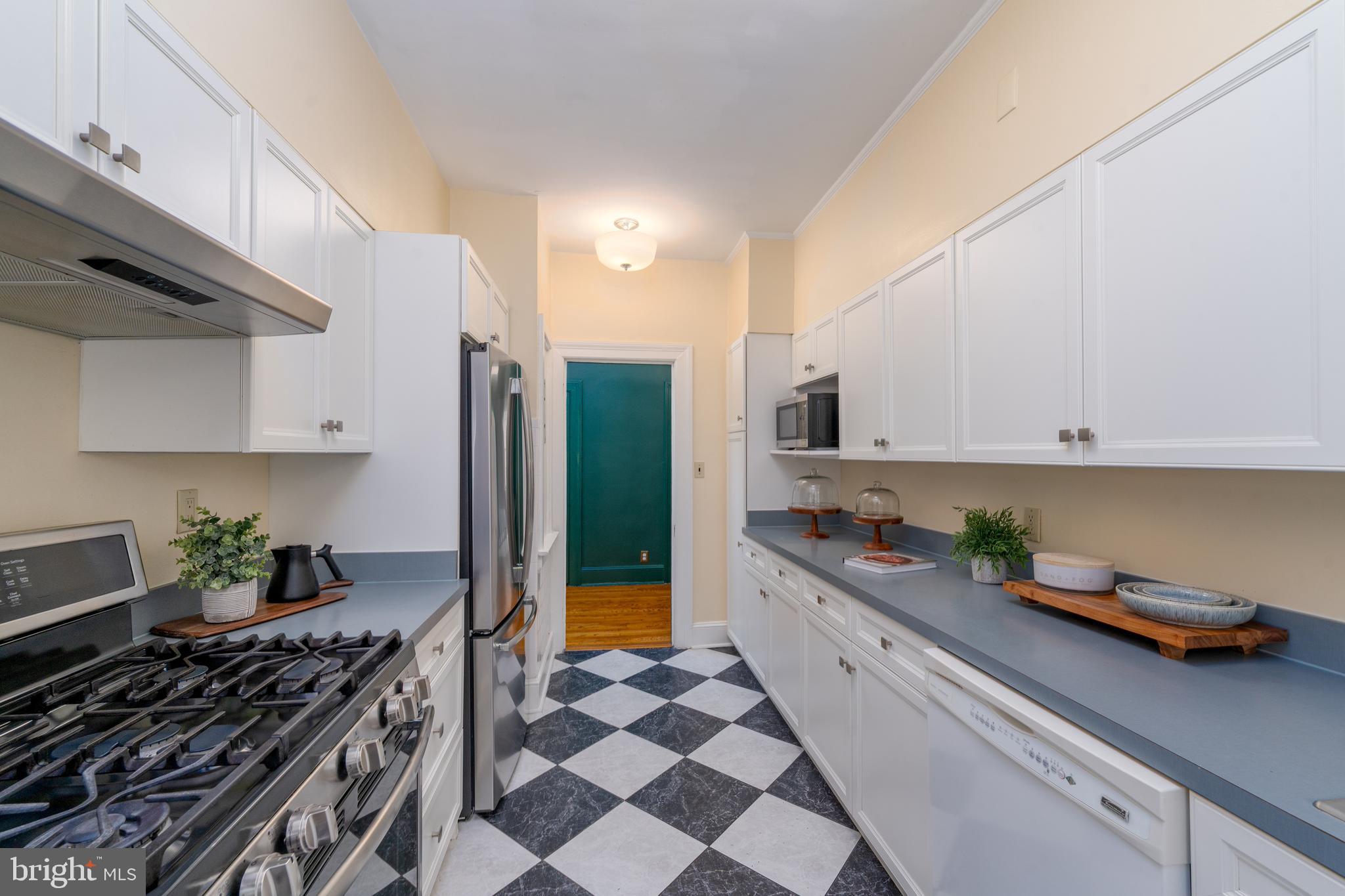 102 West 39th Street, Unit 2B Baltimore, MD 21210 - Photo 10 of 30 a kitchen with stainless steel appliances a sink a stove and a refrigerator