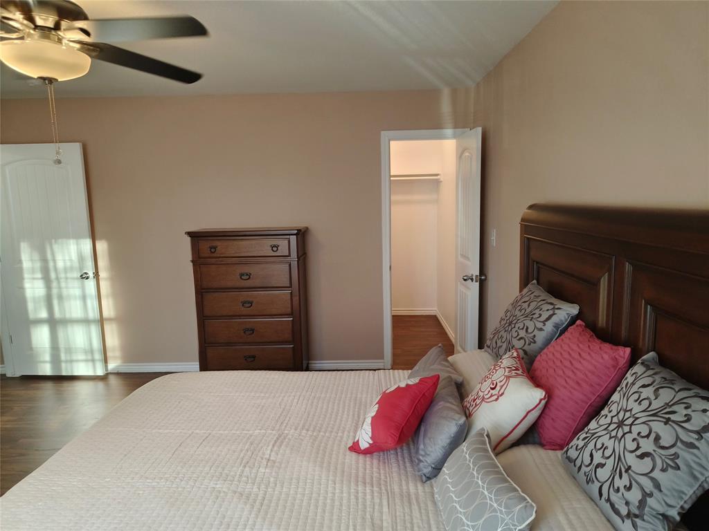 100 East Bluebonnet Drive Cresson, TX 76035 - Photo 19 of 25 Bedroom with dark wood-style floors, a spacious closet, and a ceiling fan