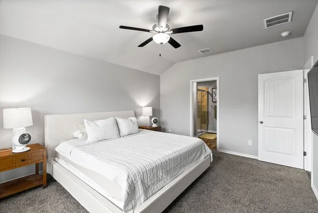 a spacious bedroom with a bed and a ceiling fan