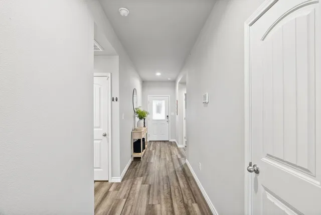 a view of a hallway with wooden floor