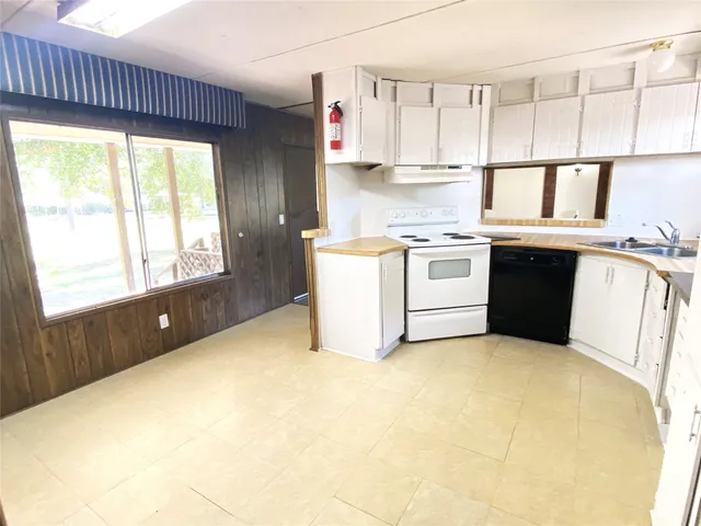 a kitchen with a stove a sink and white cabinets