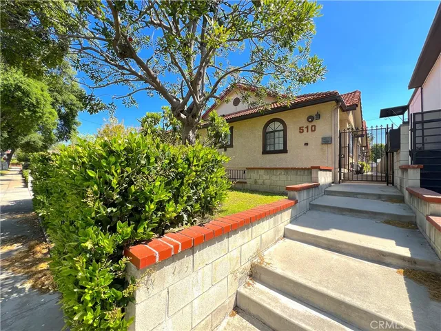 a view of an house with backyard space and a tree