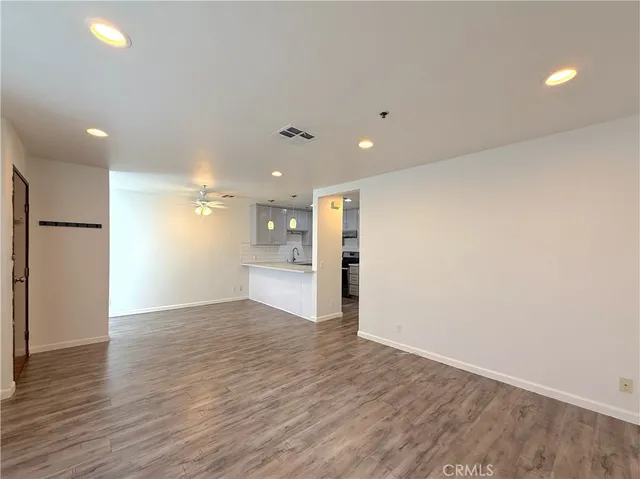 a view of an empty room with wooden floor