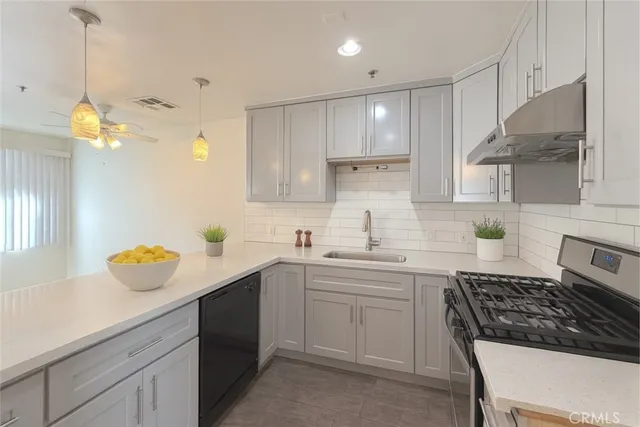 a kitchen with a sink a stove cabinets and counter space