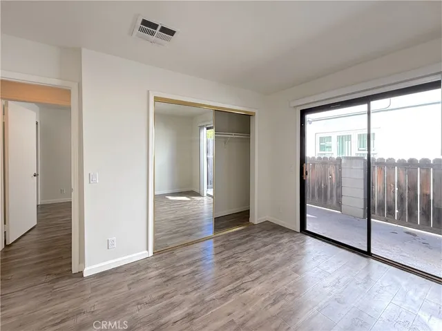 an empty room with wooden floor and sliding door
