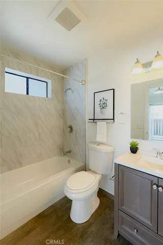a bathroom with a granite countertop toilet a sink and bathtub