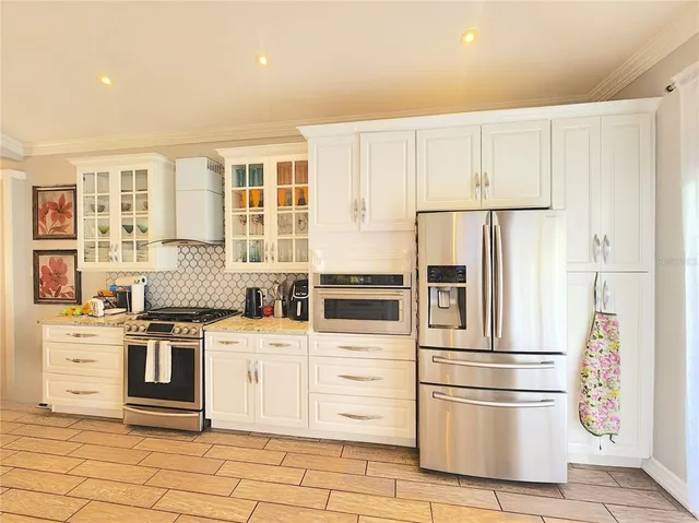 a kitchen with stainless steel appliances granite countertop a refrigerator and a stove