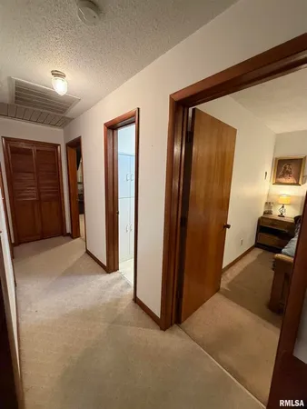 a view of a hallway with closet and wooden door