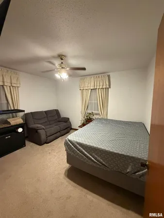 a spacious bedroom with a bed and a chandelier