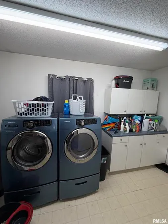 a utility room with sink dryer and washer