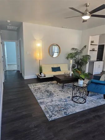 a living room with furniture and a wooden floor