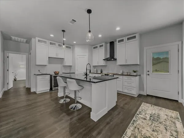 a kitchen with stainless steel appliances kitchen island hardwood floor sink and stove