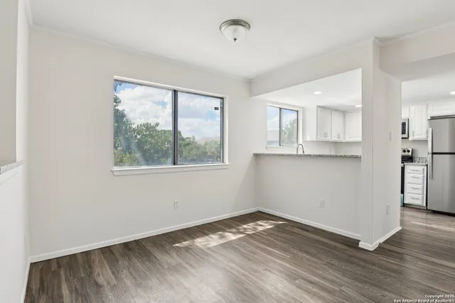 a view of a kitchen with wooden floor and a window