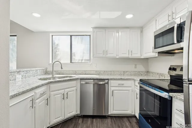 a kitchen with appliances cabinets and a sink
