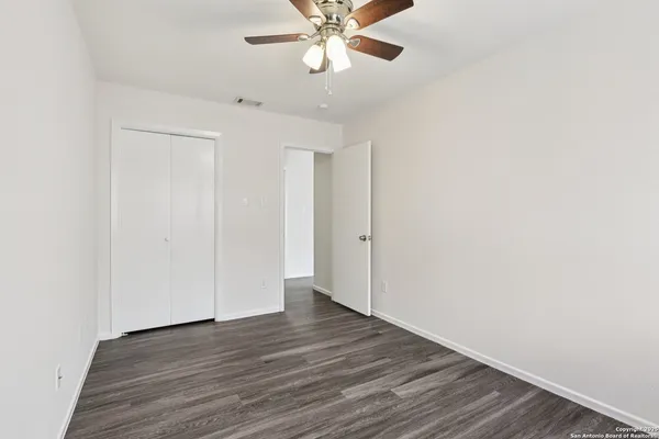 a view of an empty room with wooden floor